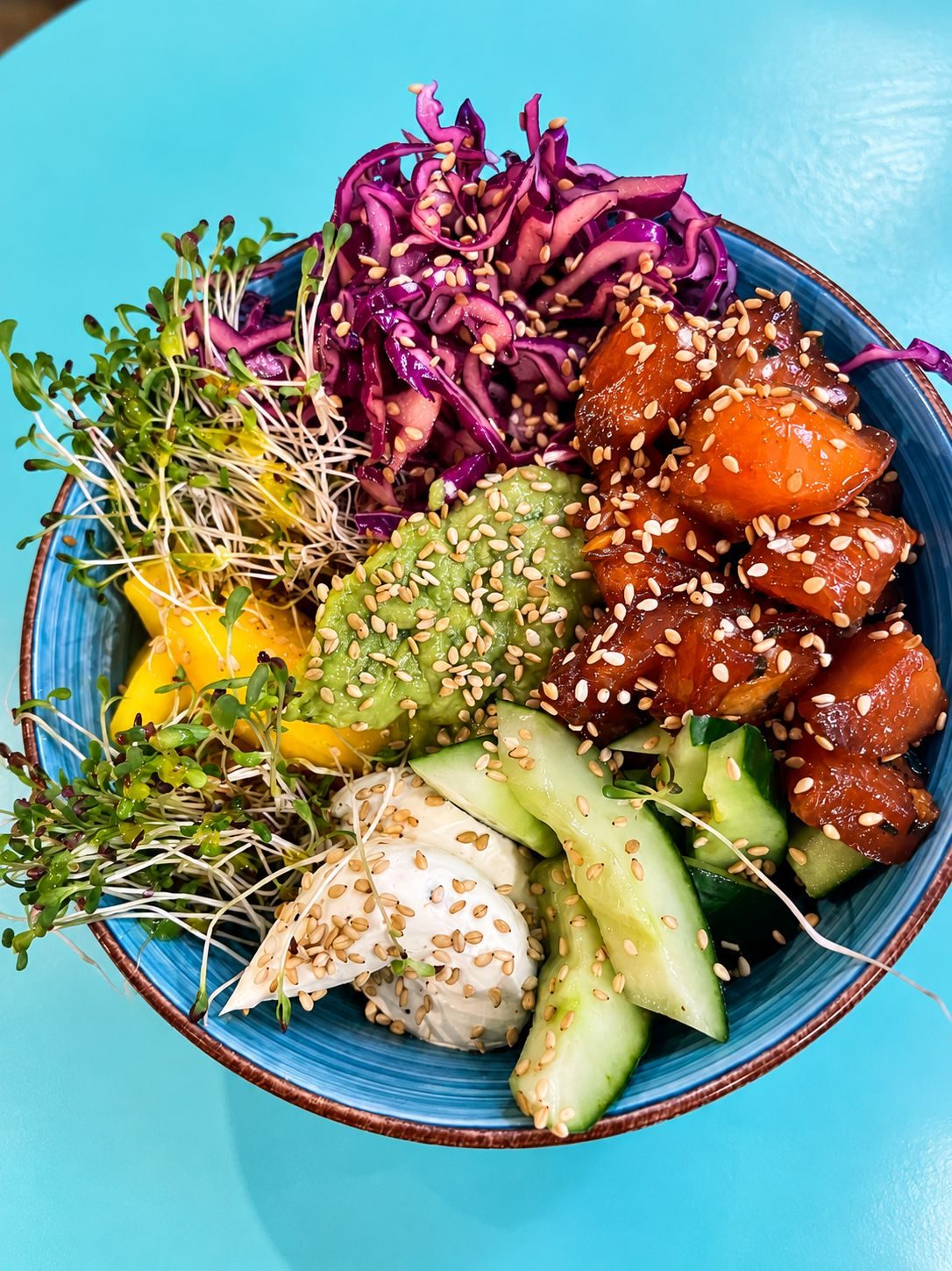 Poke bol saumon, choux rouge, mangue et crème d'avocat